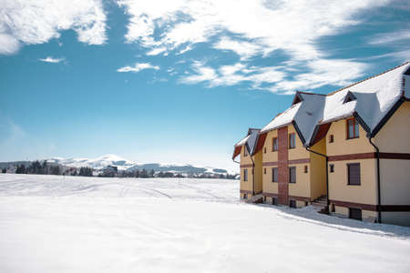 Luxurious house on a field covered with snow, copy space, direct sunlightの写真素材