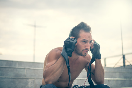 Getting motivated for hard workout, listening to the music with headphones on and gloves for trainning. Selective focusの写真素材