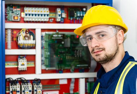 Young male electrician trying to solve the problem. Selective focus.の写真素材