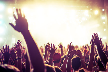 A crowd of people celebrating and partying with their hands in the air to an awesome Dj. High ISO...