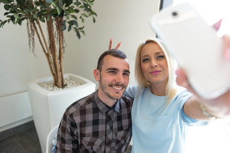 Shot of young couple taking a selfie while shopping in the shopping mall. Selective focus.の写真素材