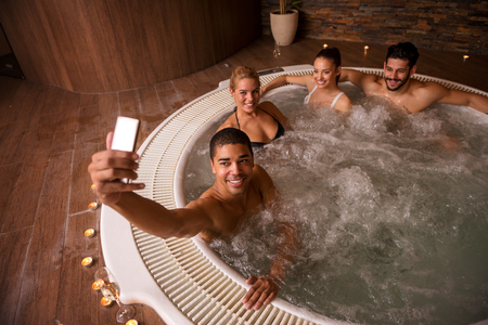 Wide angle shot of a man making selfie with friends at the spa.の写真素材