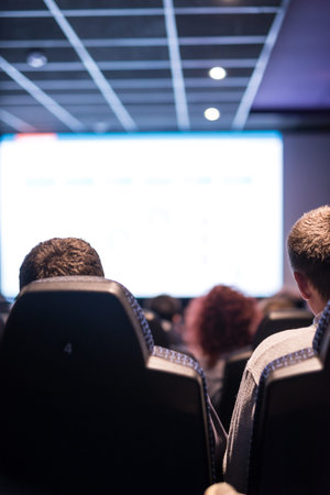 Shot of a people watching a movie in a cinema. No recognizable people.