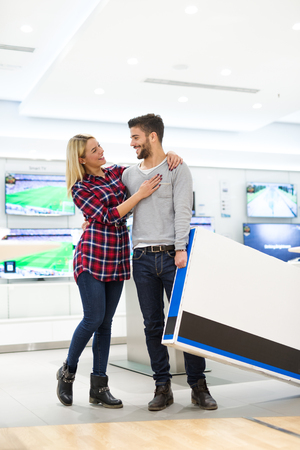 Shot of a happy couple shopping TV.の写真素材