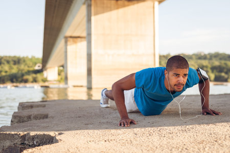 Shot of a man doing exercise outdoors next to the river.