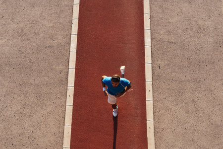 High angle shot of a man having a morning jogging. Lens flare, toned image.