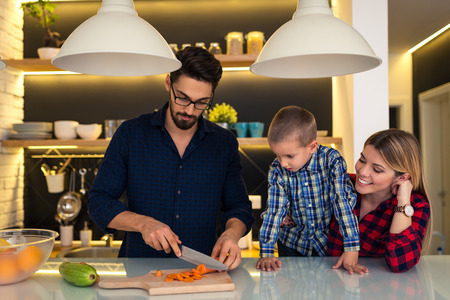 Mother and son helping father to prepare family dinner.の写真素材