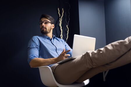 Businessman working on a laptop at night from home.の写真素材