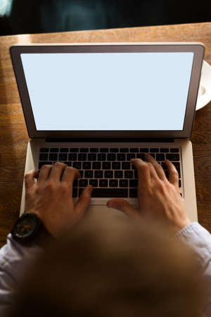 Close up of man's hands typing on a laptop keyboard.の写真素材