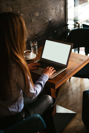 Businesswoman working on a laptop in a cafe.の写真素材