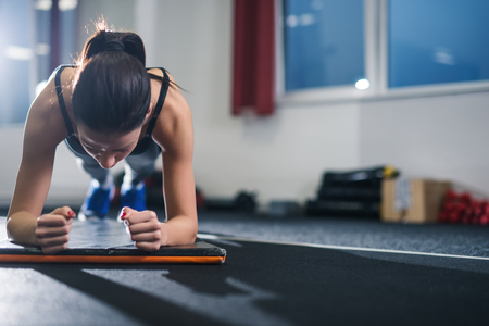 Female athlete doing exercises in a gym. Soft focus.の写真素材