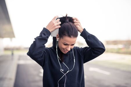 Beautiful female athlete putting the hood on.の写真素材