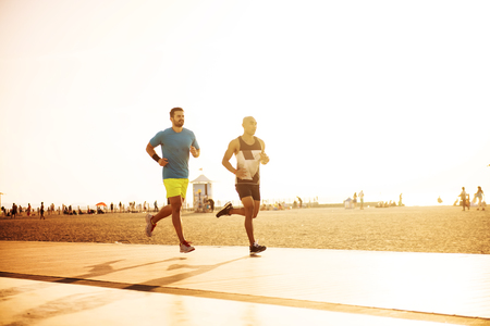 Two male athlete jogging on the beach.の写真素材
