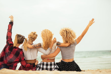 Happy friends chilling on the beach together.