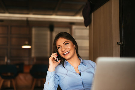 Attractive young entrepreneur talking on a mobile phone.