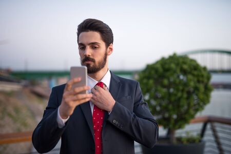 Cropped shot of a businessman in a suit adjusting his necktie.の写真素材