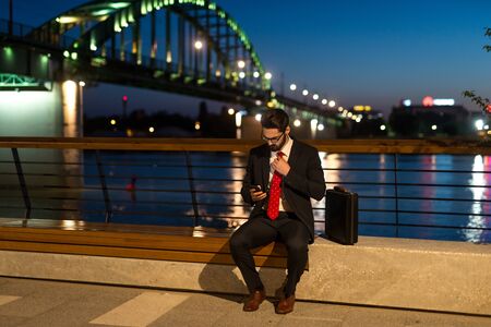 Handsome elegant businessman working overtime at night in the city.の写真素材