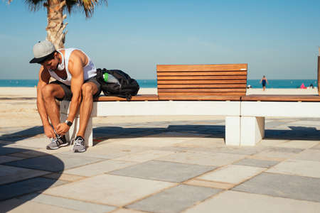 Young athlete tying a shoelace and getting ready for running.の写真素材