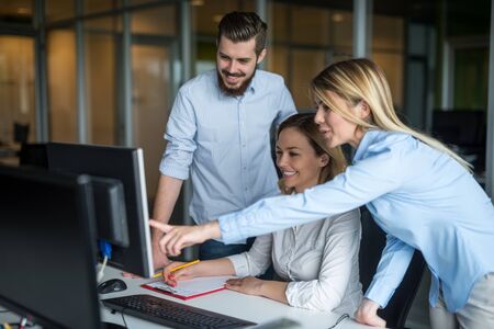 Woman showing her colleagues something on a computer.の写真素材