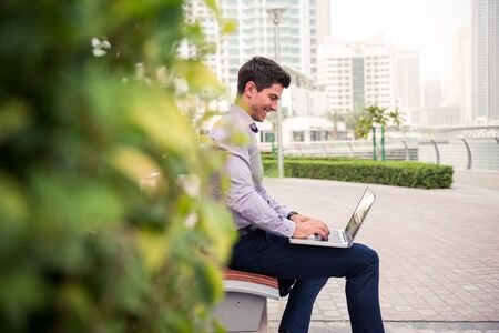 Young businessman working on a computer outdoors.の写真素材