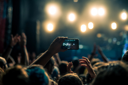 Woman capturing festival moments on the stage.の写真素材