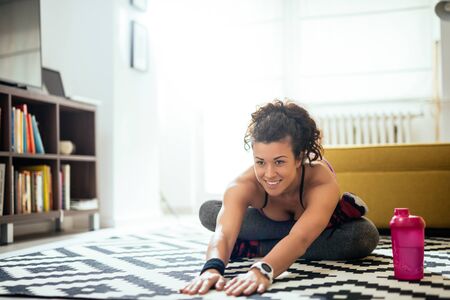 Woman doing stretching exercises at home.の写真素材