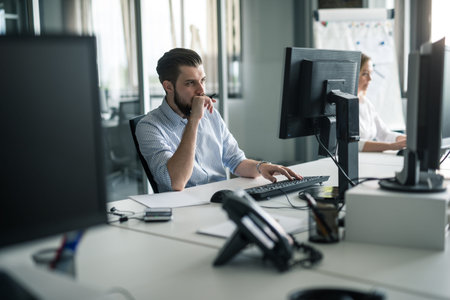 Handsome businessman working on a computer in an office.
