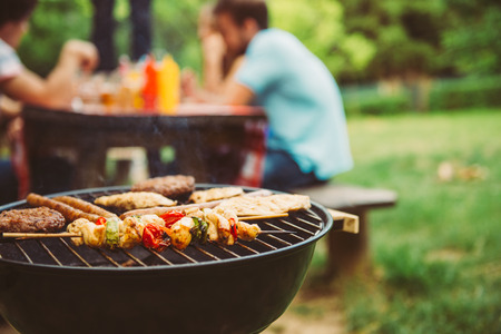 Friends making barbecue and having lunch in the nature.の写真素材