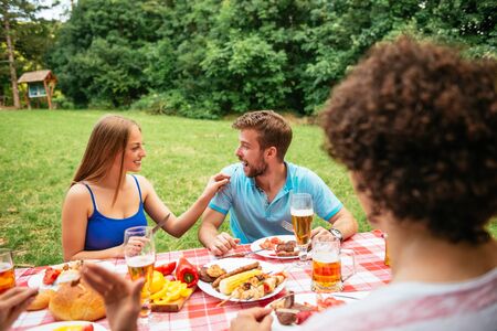 Two couple eating and having picnic outdoors.の写真素材