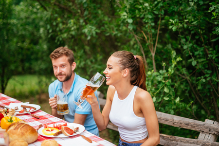Friends drinking beer and having fun on a picnic.の写真素材