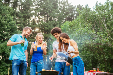 Friends enjoying drinks while making barbecue together.