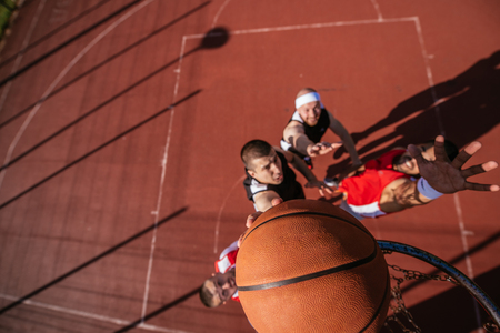 Young basketball player scoring a slam dunk.の写真素材