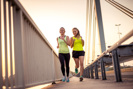 Friends enjoying evening jog on the bridge.の写真素材