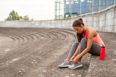 Young girl tying a shoe lace and getting ready for training.の写真素材