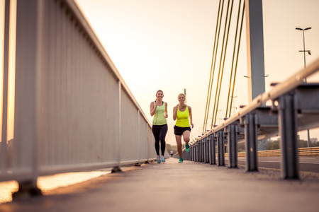 Attractive girls enjoying an evening jog together.の写真素材
