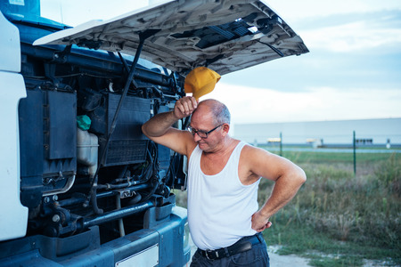 Senior truck driver trying to fix a truck.の写真素材