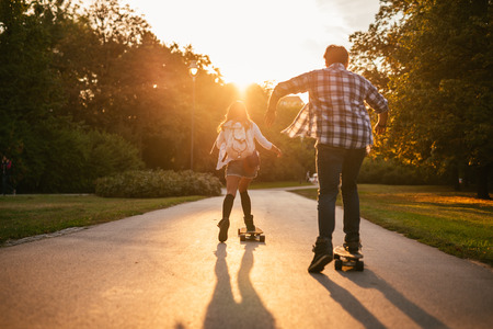 Friends learning how to drive a long board.の写真素材
