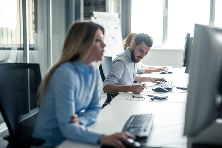 Happy colleagues working together in an office.の写真素材