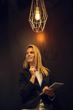 Attractive woman holding a tablet in an office.の写真素材