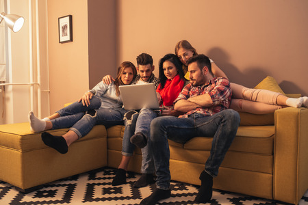 Friends enjoying a movie time at home.の写真素材