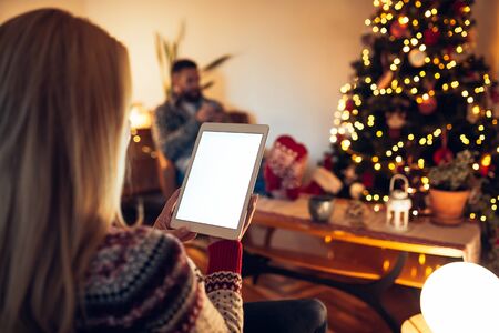 Rear view of a woman using tablet at home.の写真素材