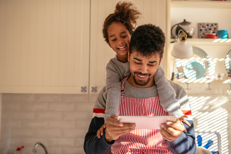 Dad and daughter finding recipes on a tablet together.の写真素材