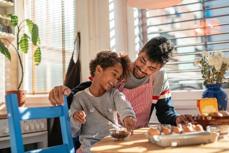 Dad and daughter baking together in the kitchen.の写真素材
