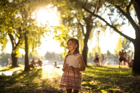 Cute young girl enjoying a walk in the park.の写真素材