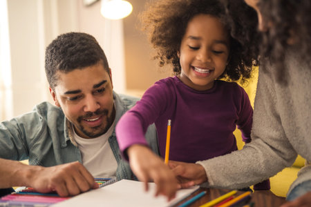 African american family drawing in the living room and spending some fun time together.