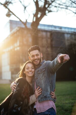 Photo of a stylish couple hanging out in the city at sunset.の写真素材