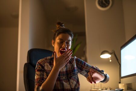 Portrait of a beautiful overworked businesswoman yawning.の写真素材
