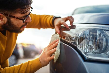 Shot of a young man polishing his car with a microfiber cloth.の写真素材