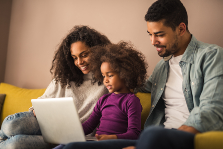 Portrait of happy african american family bonding with computer.の写真素材
