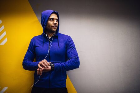 Handsome sportsman checking his time after workout.の写真素材